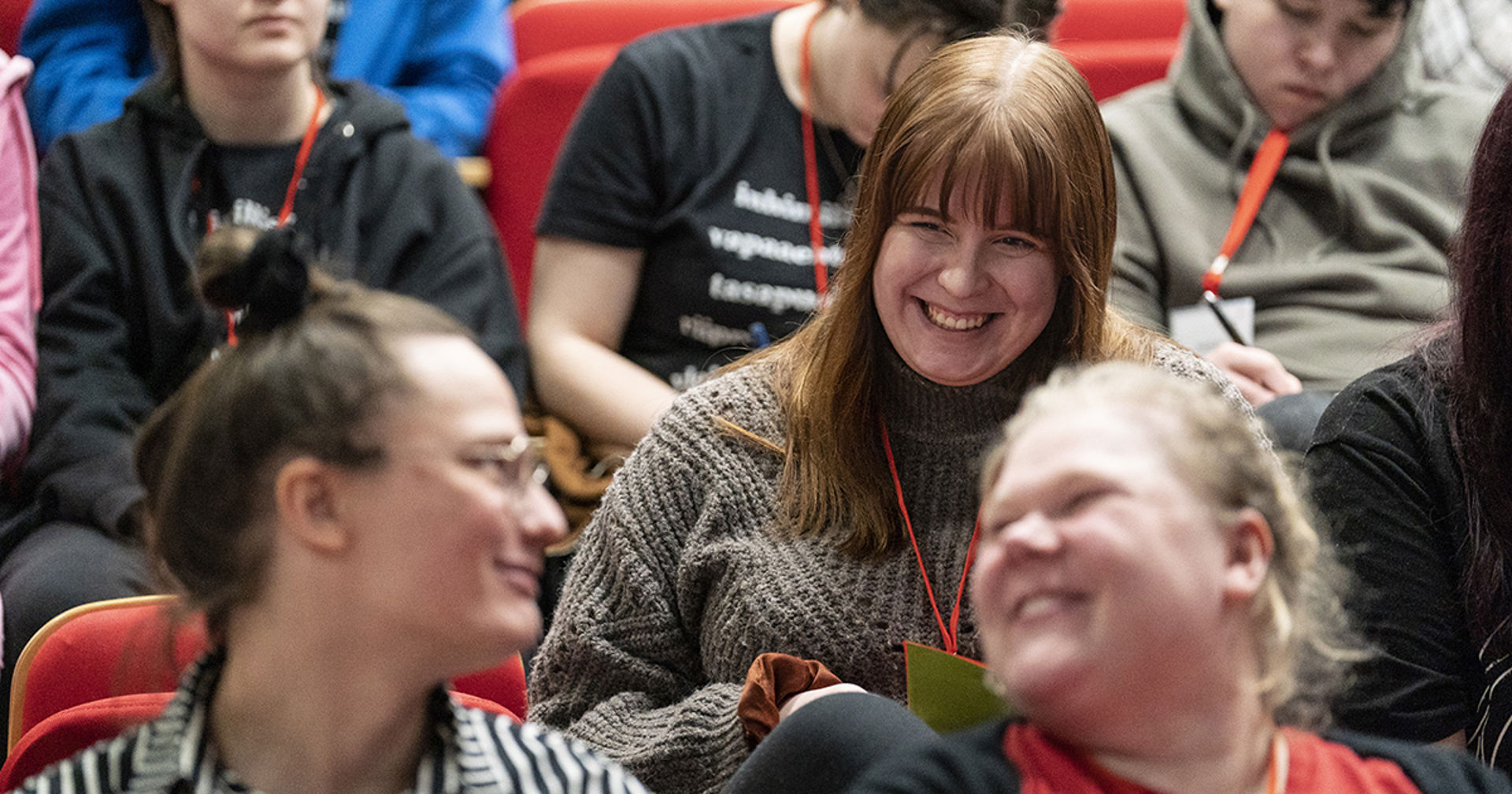 Tre frivilliga ler mot varandra.