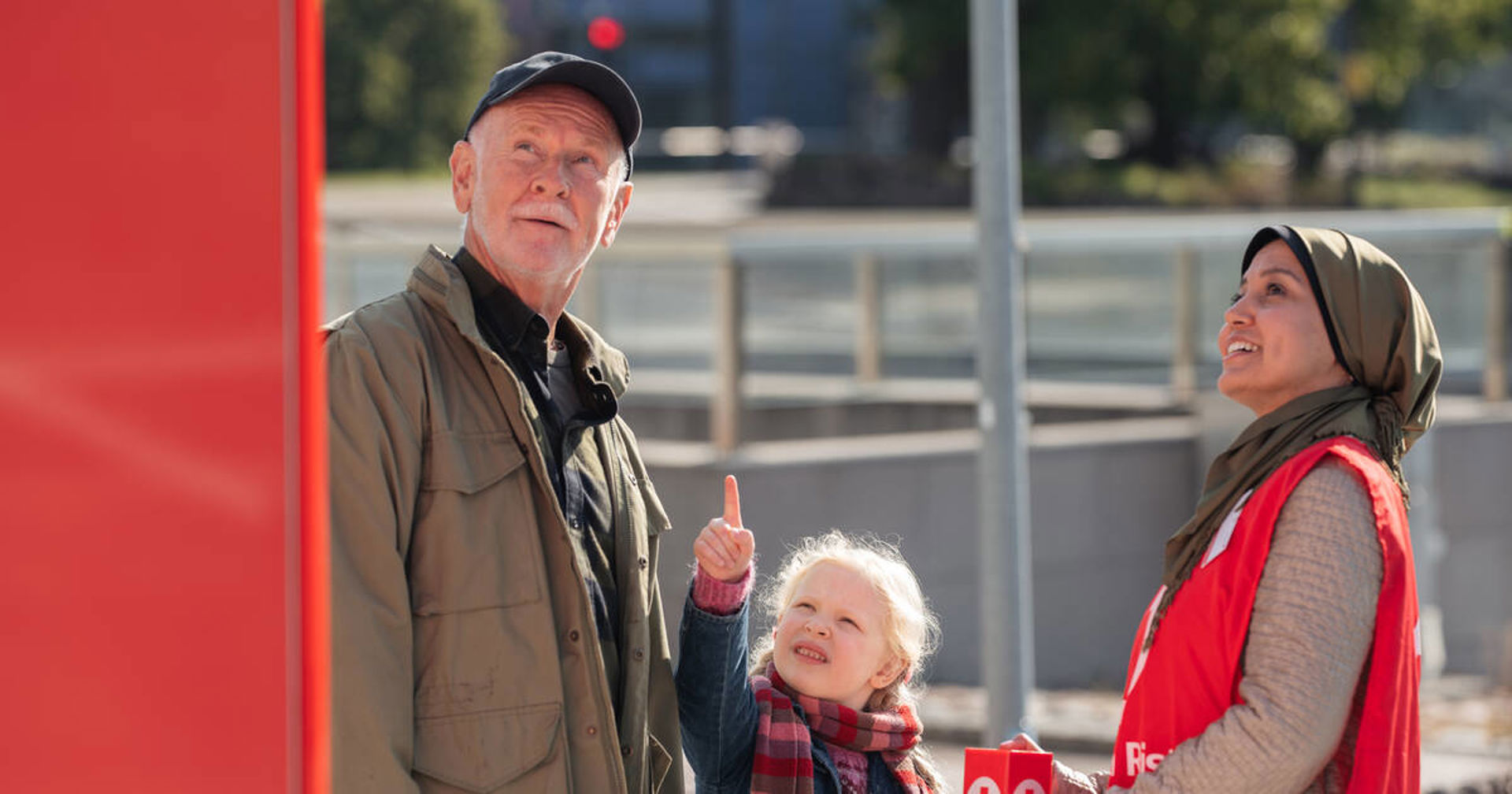 Tre personer. En person har på sig Röda Korsets frivilligväst och håller i en insamlingsbössa.
