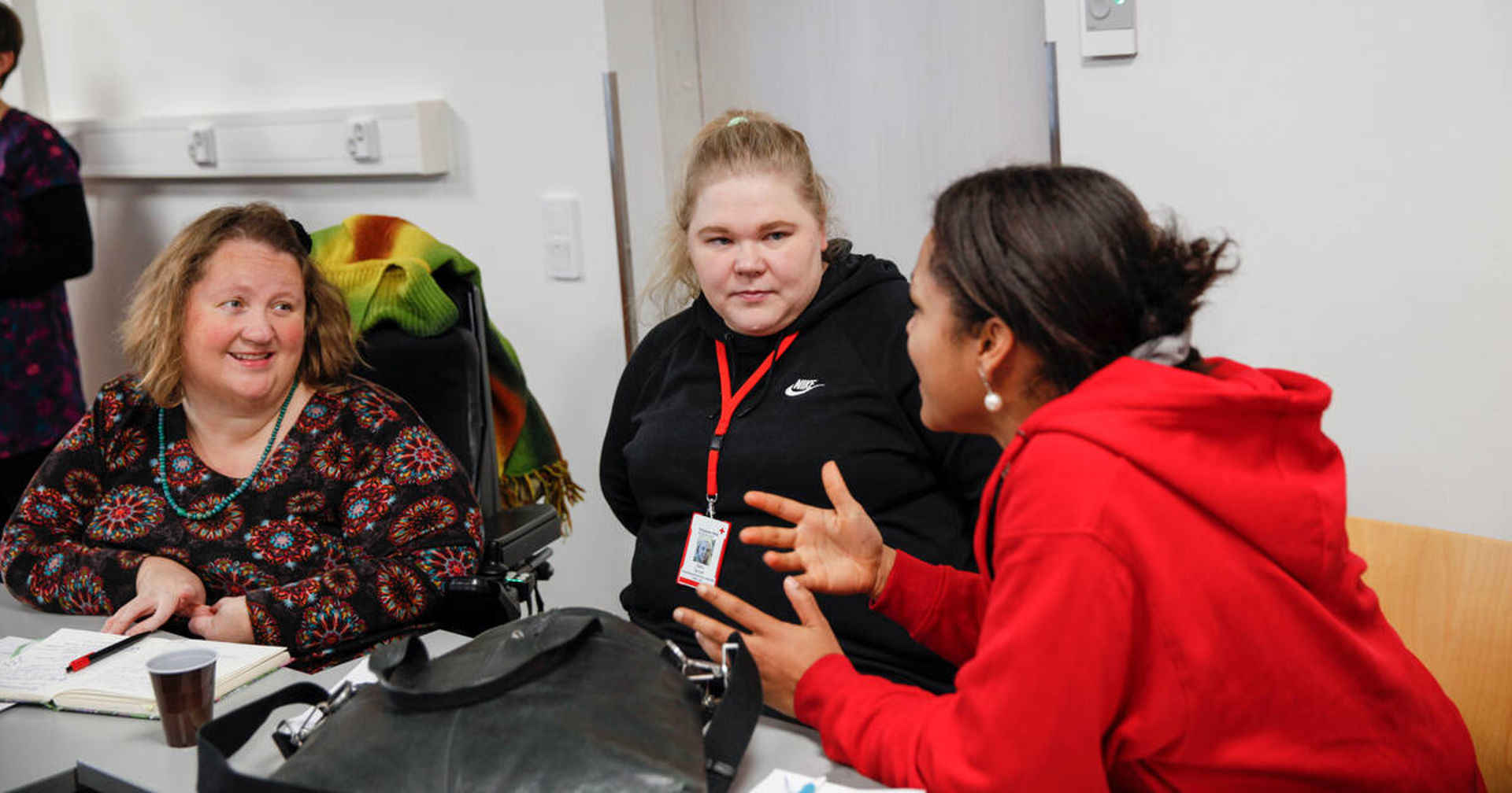 Tre personer samtalar.