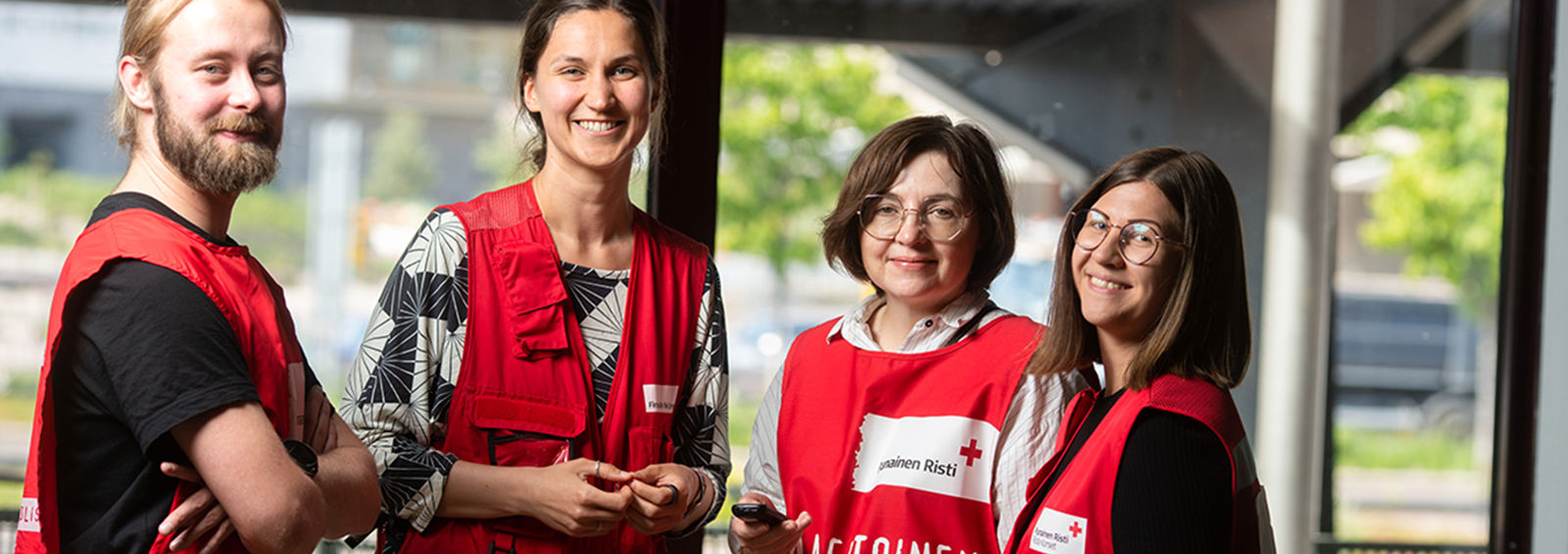 Fyra frivilliga står och ler mot kameran.