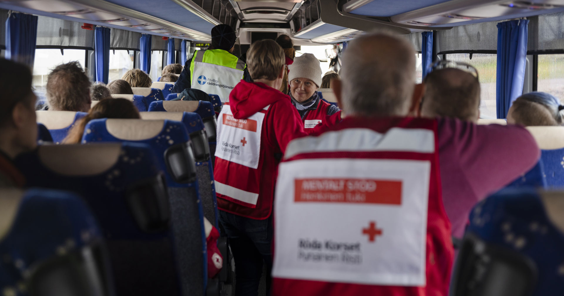 Frivilliga från Röda Korset i en buss med sina frivilligvästar.