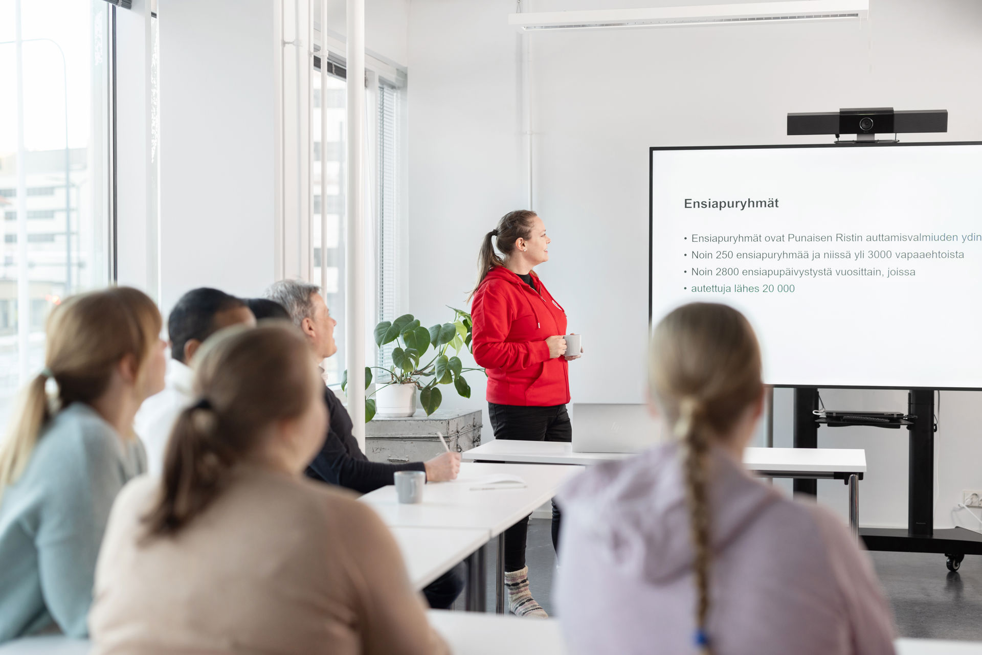 En Röda Korset-frivillig tittar på en whiteboard i ett undervisningsrum.