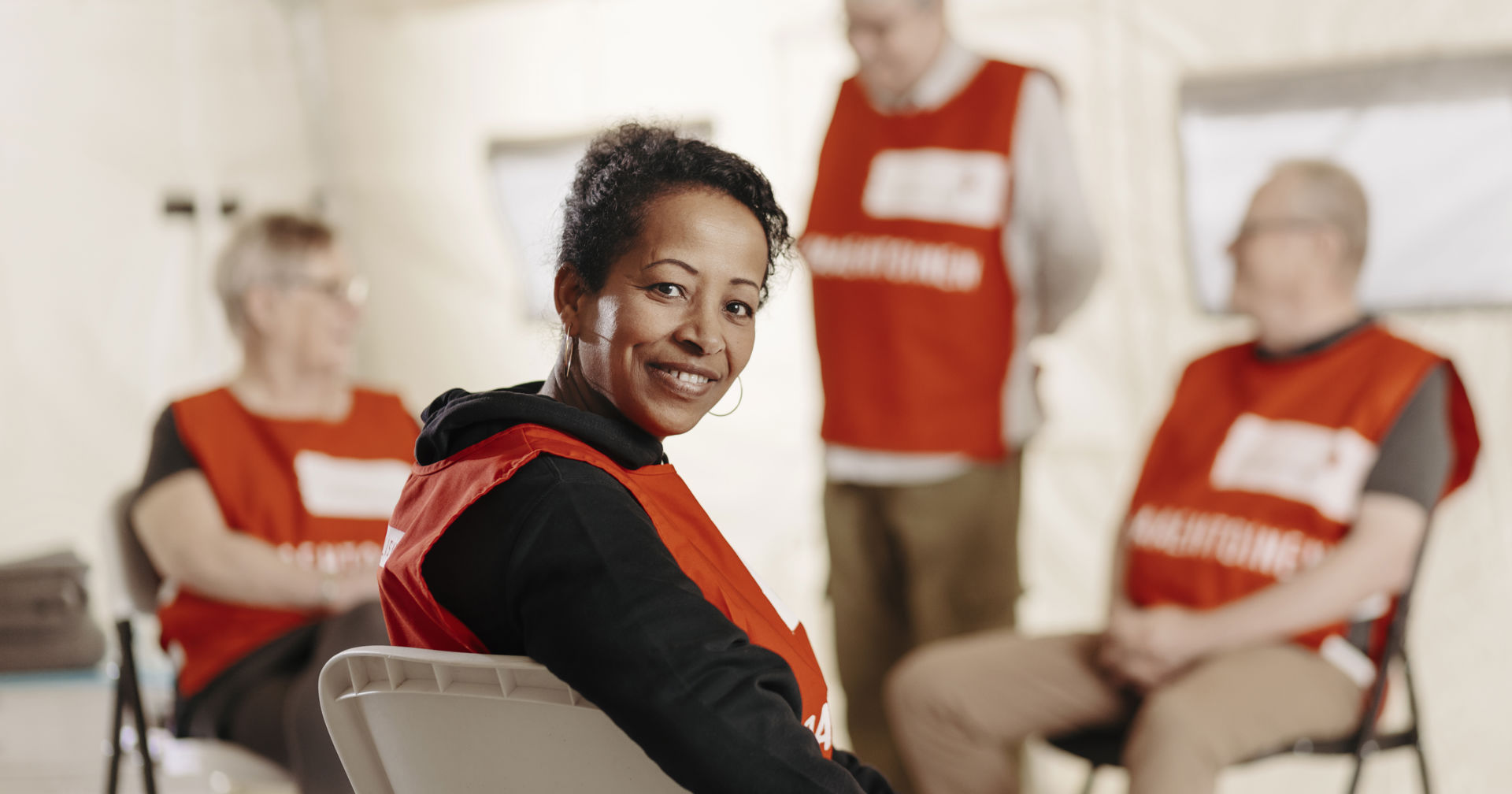 En leende frivillig som tittar in i kameran.