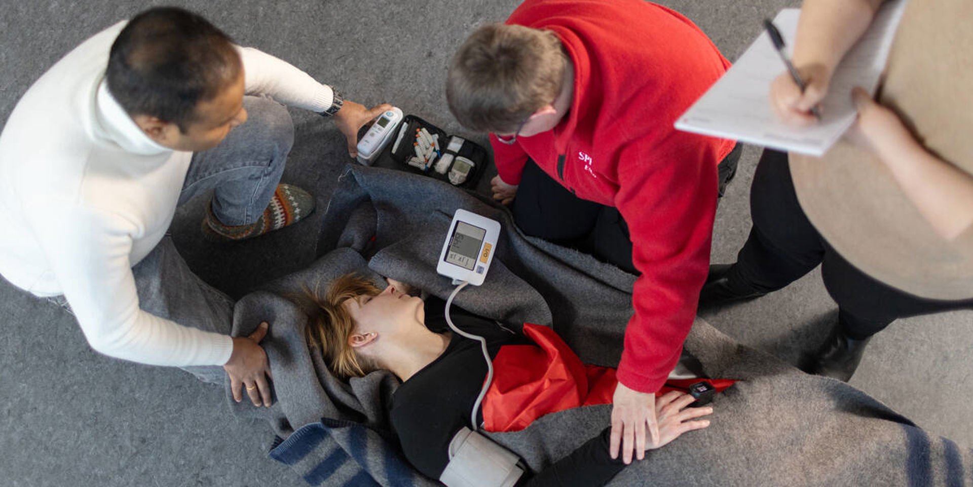 Två personer bär en tredje person på bår.