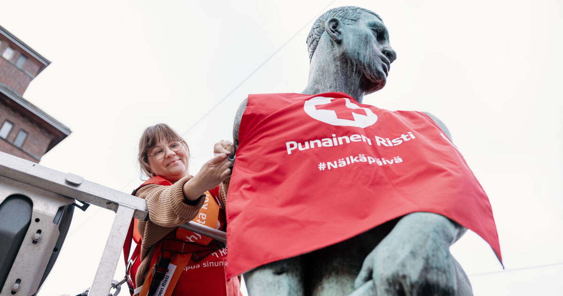 En person klär en staty i en Hungerdagen-väst.