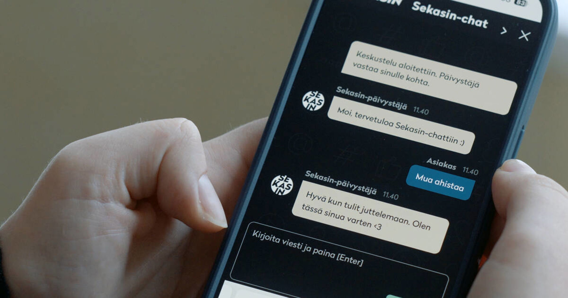 Händer på en telefonskärm med Sekasin-chatten öppen. Röda Korset är en del av Sekasin Kollektivet, som svarar för Sekasin-chattens verksamhet.