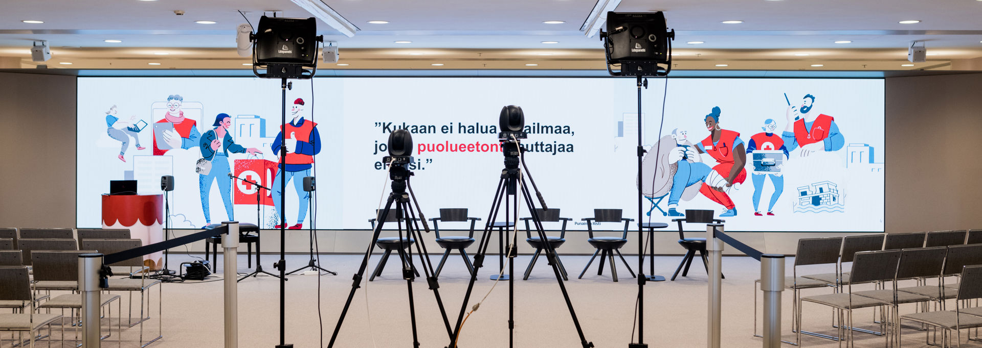 Röda Korsets bildmaterial projicerat på väggen och texten på finska: "Ingen vill ha en värld där det inte finns en opartisk hjälpare."
