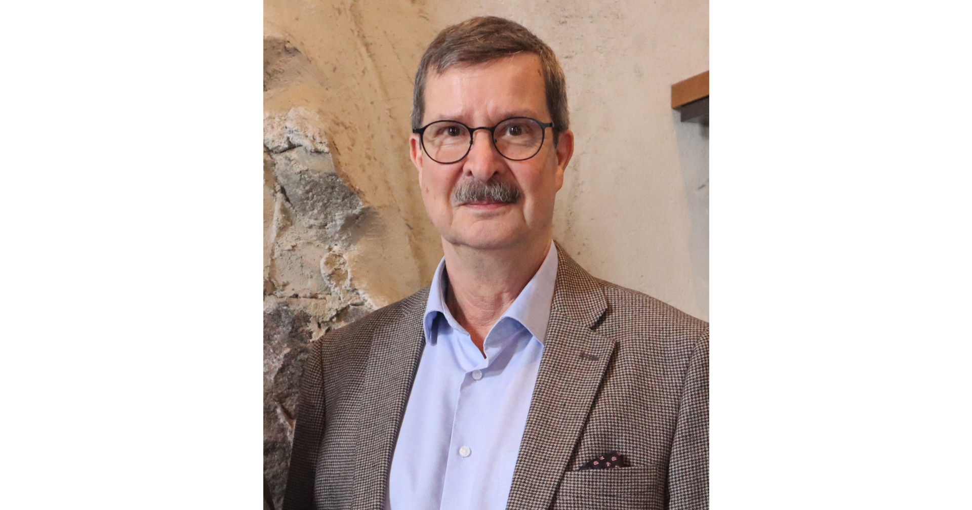Kenneth Nygård tittar mot kameran, klädd i en ljus skjorta och en brunaktig kavaj.