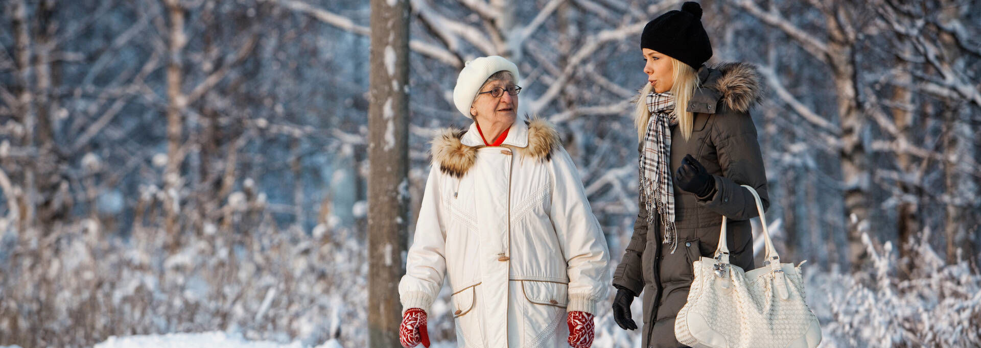 Två personer promenerar i ett snöigt landskap.