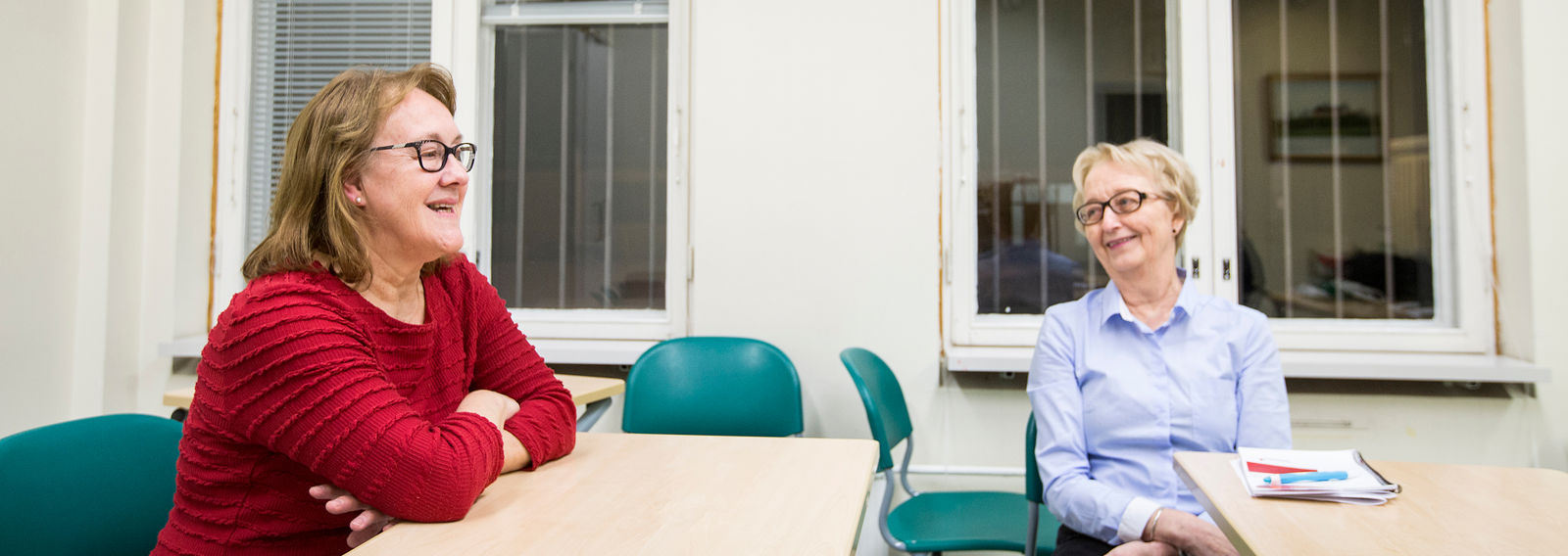 Två personer sitter vid ett bord och pratar.