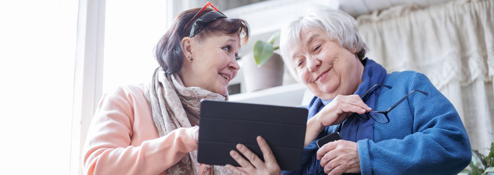 Två personer tittar på en surfplatta.